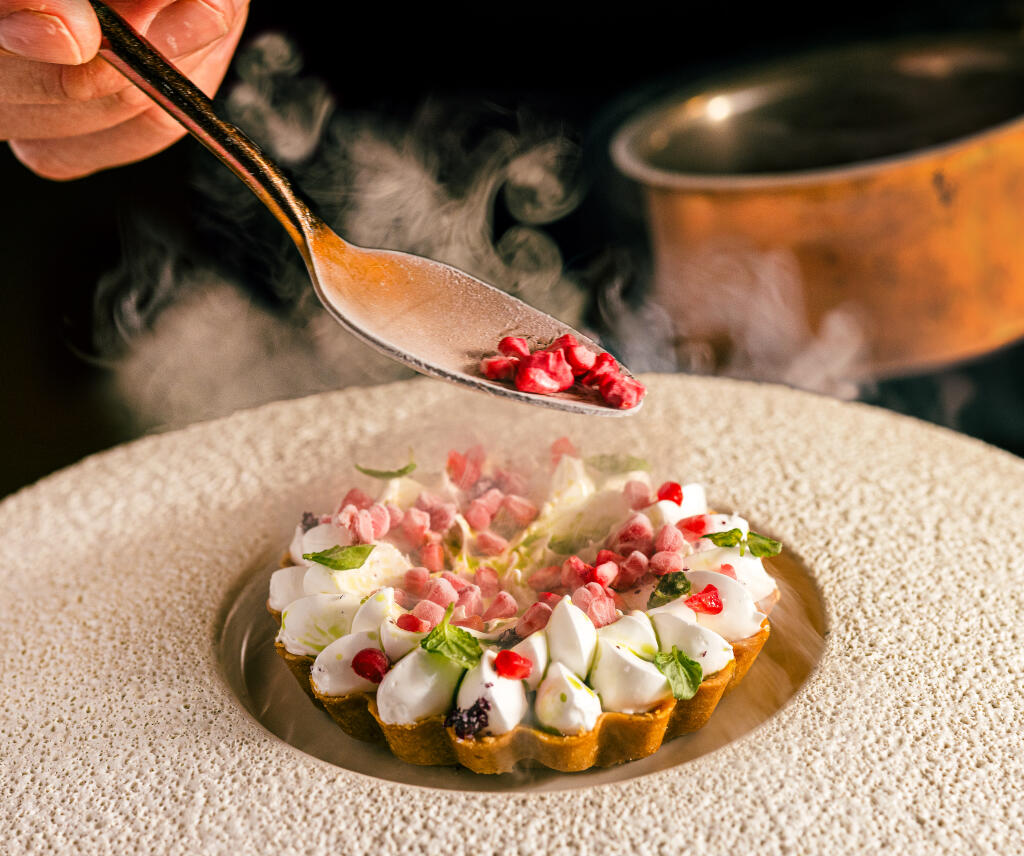 Raspberry Lime Tart with rose meringue, topped with shiso oil and pomegranate seeds frozen in dry ice from Cyrus Restaurant pastry chef Josh Gaulin, Friday, Feb. 2, 2024, in Geyserville. (John Burgess / The Press Democrat)