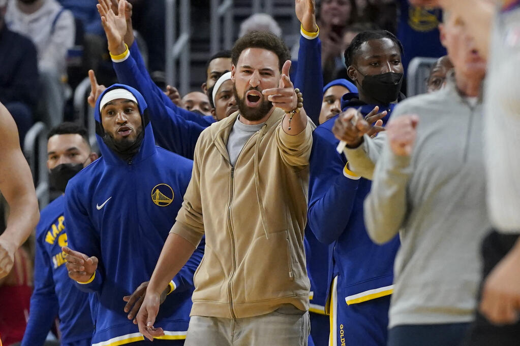 Injured Golden State Warriors guard Klay Thompson, center, gestures during the second half against the Oklahoma City Thunder in San Francisco on Saturday, Oct. 30, 2021. (Jeff Chiu / ASSOCIATED PRESS)