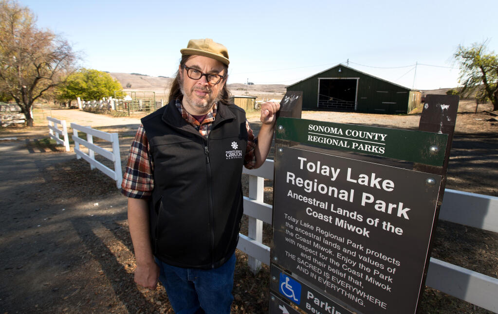 Matthew Johnson, of Petaluma, a tribal citizen of Federated Indians of Graton Rancheria who coleads educational field trips for children visiting the park, stands next to a park sign Thursday, Oct. 13, 2022, at Tolay Lake Regional Park in Petaluma. (Darryl Bush / For The Press Democrat)