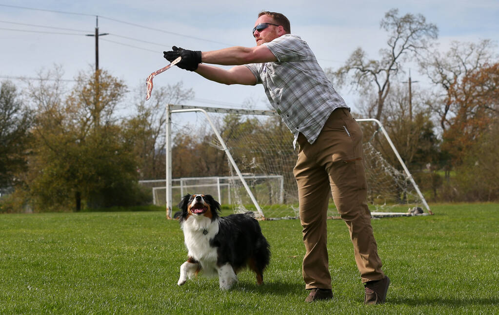 David Morgan tries to catch a boomerang with his dog Halley at a Wilson Ranch Soccer Park in Windsor on Friday, March 17, 2023. Morgan learned to throw a boomerang because Hallie doesn’t like to play fetch. (Christopher Chung / The Press Democrat)