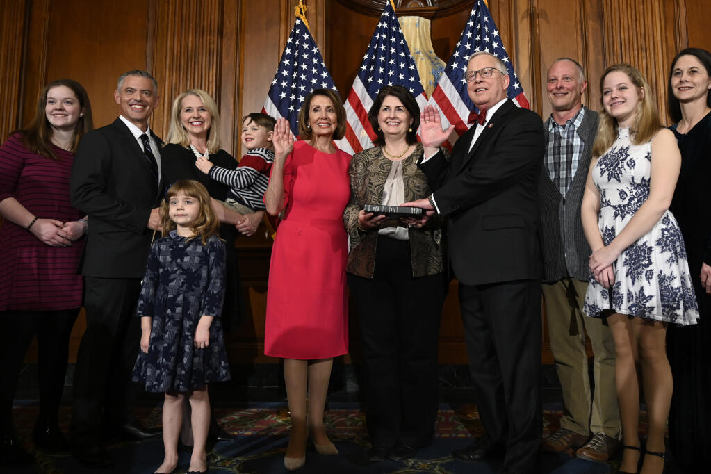 FILE - In this Jan. 3, 2019 file photo, House Speaker Nancy Pelosi of Calif., poses during a ceremonial swearing-in with Rep. Ron Wright, R-Texas, fourth from right, on Capitol Hill in Washington during the opening session of the 116th Congress. Wright, the Texas Republican who had battled health challenges over the past year including lung cancer treatment died Sunday, Feb. 7, 2021, more than two weeks after contracting COVID-19, his office said Monday, Feb. 8.  He was 67. (AP Photo/Susan Walsh, File)