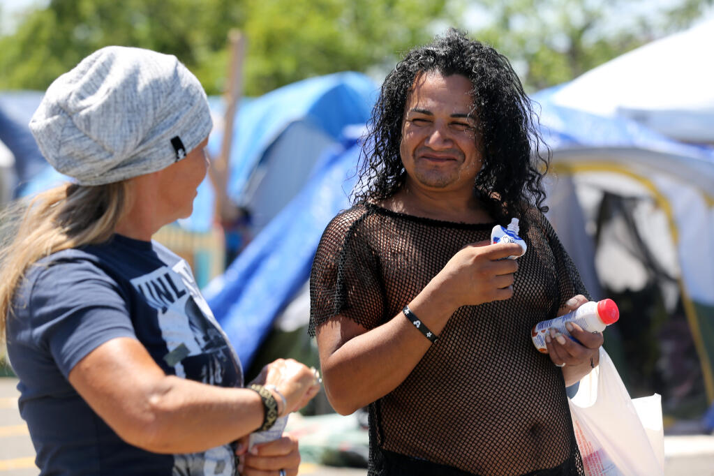 Resident Leo Robles, right, talks with volunteer Sherrie Vaughn at a homeless encampment at a public parking lot off Roberts Lake Rd in Rohnert Park, Calif. on Thursday, June 9, 2022. (Beth Schlanker/The Press Democrat)
