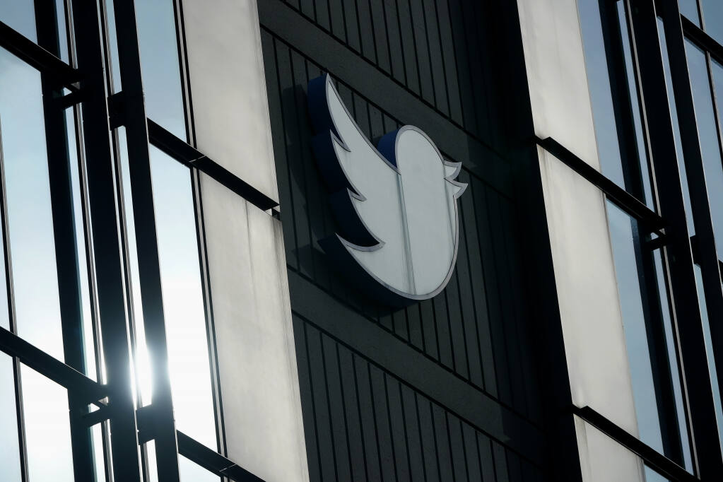 FILE - A Twitter logo hangs outside the company's offices in San Francisco, on Dec. 19, 2022. William Shatner, Monica Lewinsky and other prolific Twitter commentators — some household names, others little-known journalists — could soon be losing the blue check marks that helped verify their identity on the social media platform. (AP Photo/Jeff Chiu, File)