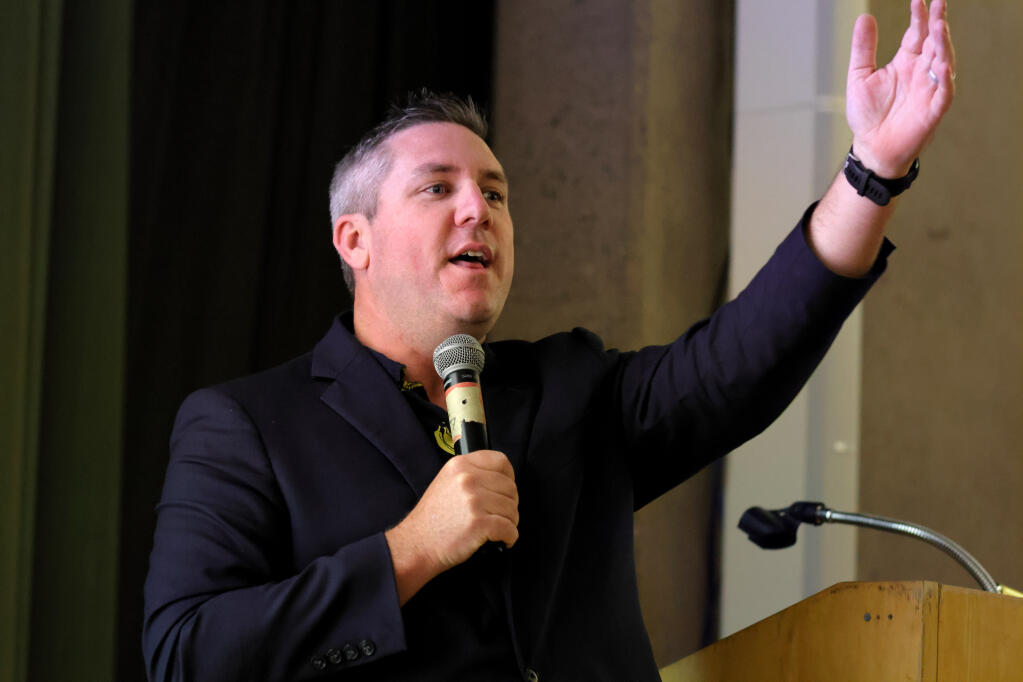 Chris Rogers, Santa Rosa City Council Member, conducts a live ask for donations during Sonoma County Bicycle Coalition’s inaugural Golden Spoke Gala at Finley Community Center in Santa Rosa on Saturday, Sept. 30. (Darryl Bush / For The Press Democrat)
