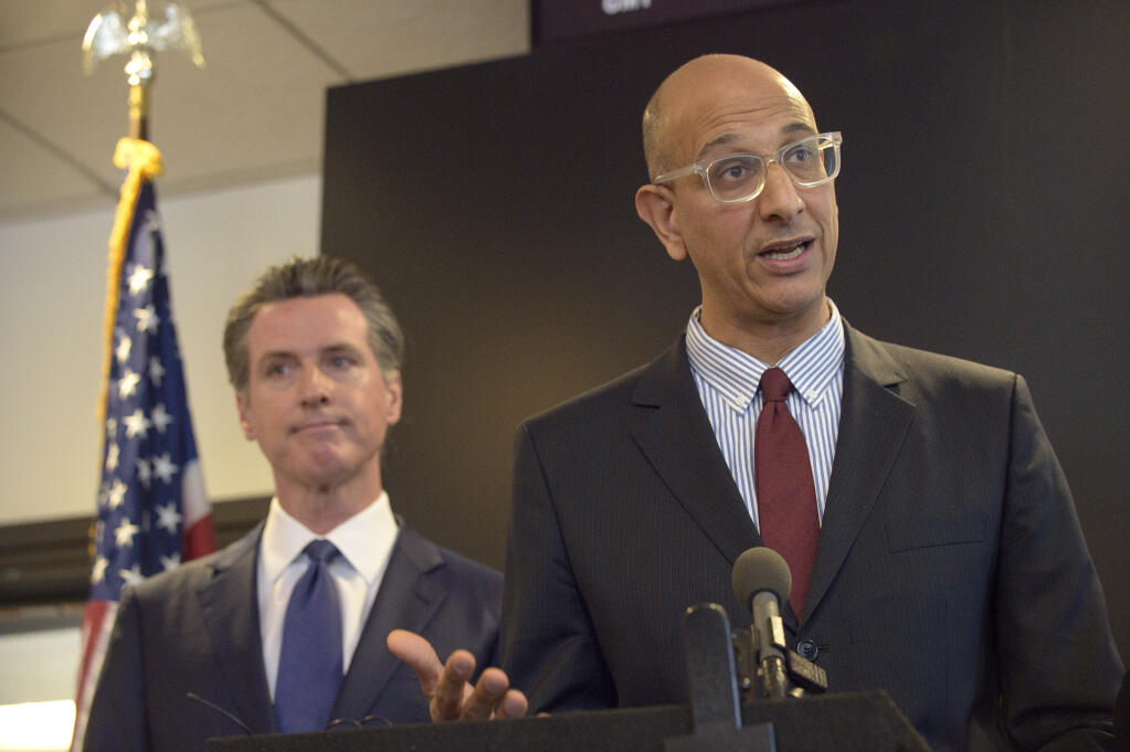 FILE - In this Feb. 27, 2020, file photo, California Health and Human Services Agency Secretary Dr. Mark Ghaly speaks at a news conference in Sacramento, Calif., as Gov. Gavin Newsom listens. (AP Photo/Randall Benton, File)