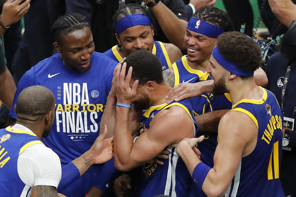 Golden State Warriors guard Stephen Curry, center, celebrates with teammates after beating the Boston Celtics in Game 6 to win basketball's NBA Finals championship, Thursday, June 16, 2022, in Boston. (AP Photo/Michael Dwyer)