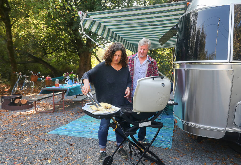 Claudia Sutton and John Stave prepare corn for Grilled Chipotle Corn Salad at the Duncans Mills Camping Club in Duncans Mills on Wednesday, Oct. 7, 2020.  (Christopher Chung / The Press Democrat)