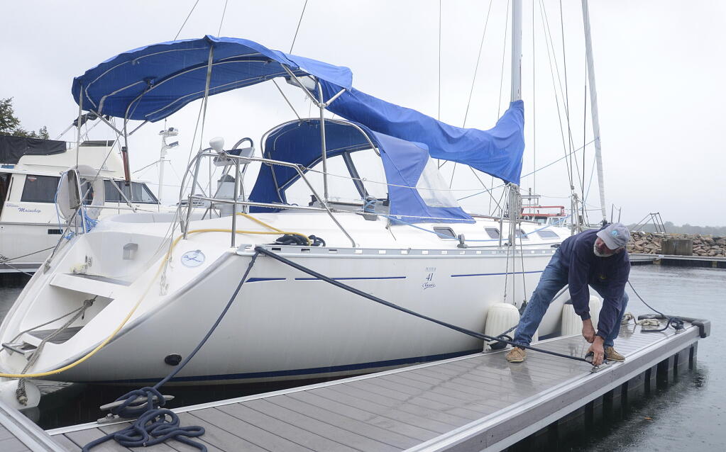 Rick Ellerbrook double checks the lines his sailboat moored in Sydney, Nova Scotia, late Friday, Sept. 23, 2022. Hurricane Fiona is poised to become a "very powerful" post-tropical storm by the time it makes landfall in eastern Nova Scotia this weekend, forecasters said Friday.  (Vaughan Merchant/The Canadian Press via AP)