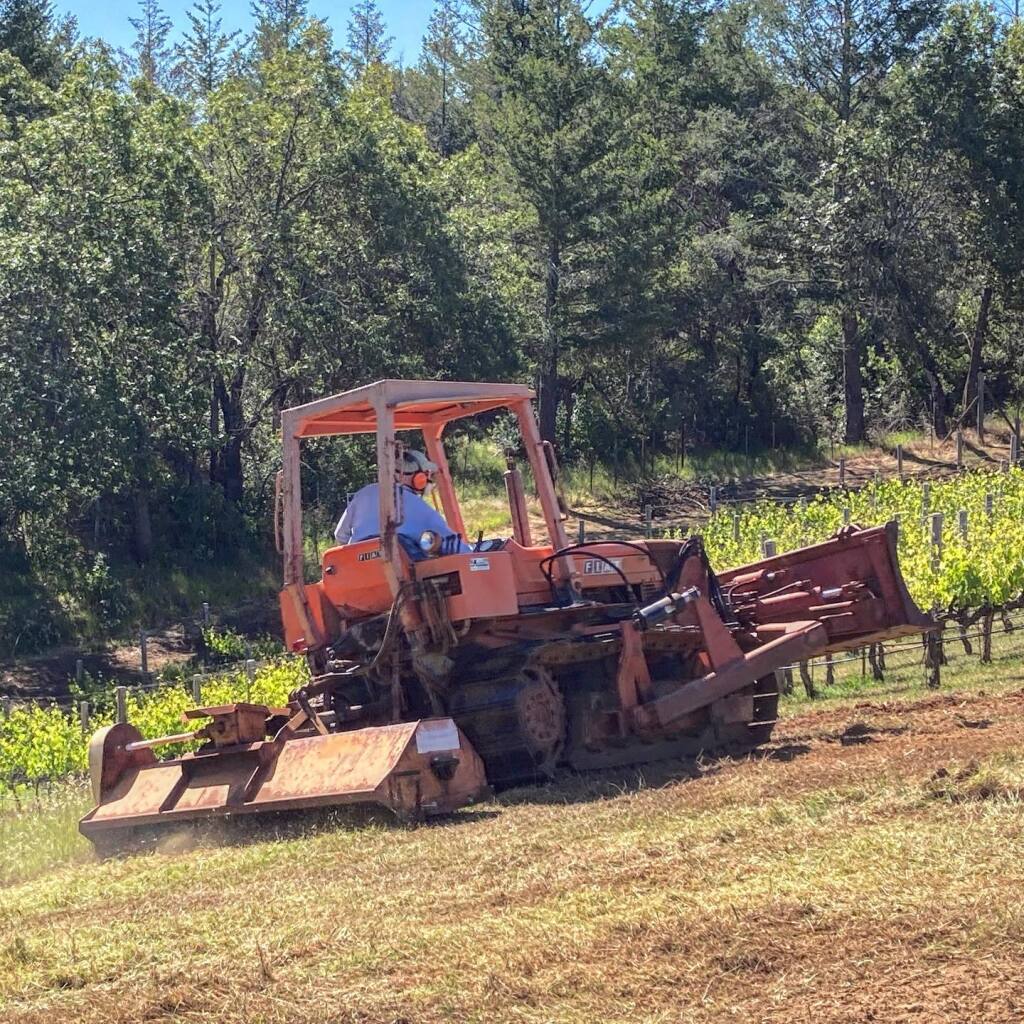 Lagier Meredith Vineyard co-owner Steve Lagier drives a tractor to mow tall grass around the 4.5 acres of vines on the property northwest of Napa in May. (Lagier Meredith Vineyard / Facebook)