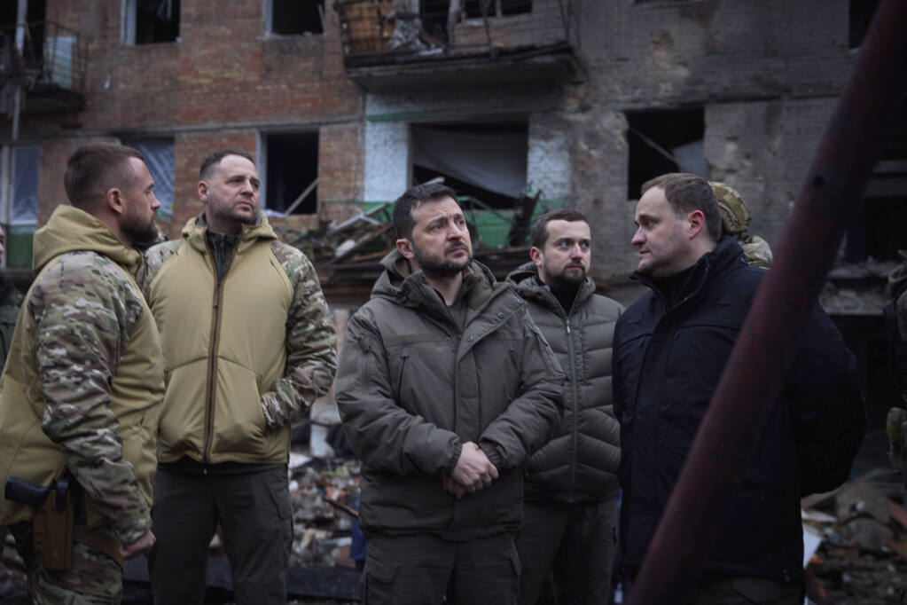 In this photo provided by the Ukrainian Presidential Press Office on Friday, Nov. 25, 2022, Ukrainian President Volodymyr Zelenskyy inspects damaged buildings as he visits town of Vyshgorod outside the capital Kyiv. (Ukrainian Presidential Press Office via AP)