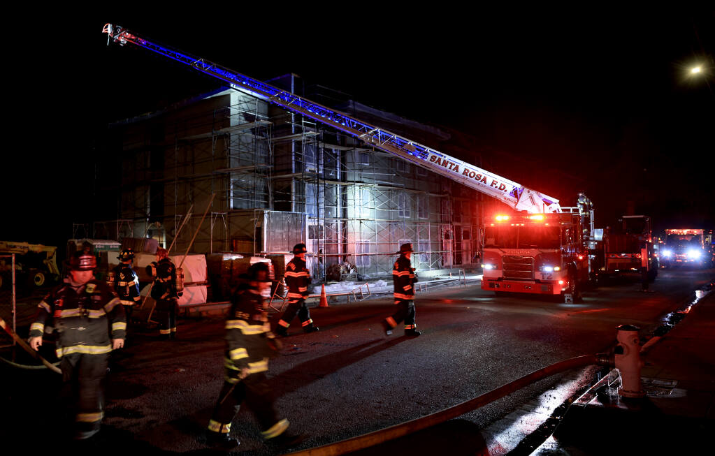 Santa Rosa firefighters begin their removal of fire apparatus after extinguishing a fire broke out in the partially completed Pullman Lofts apartment complex on Wilson and West Ninth Streets in Santa Rosa, Friday, Feb. 4, 2022. (Kent Porter / The Press Democrat) 2022