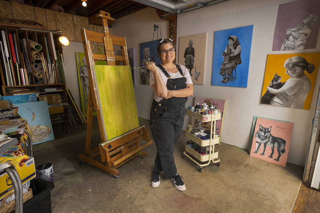 Artist and teacher Melissa Jones in her Occidental studio Oct. 21, 2022. Jones was inspired to start her new painting series, “The Spinsters and Their Pussies,” during the pandemic. (John Burgess/The Press Democrat)