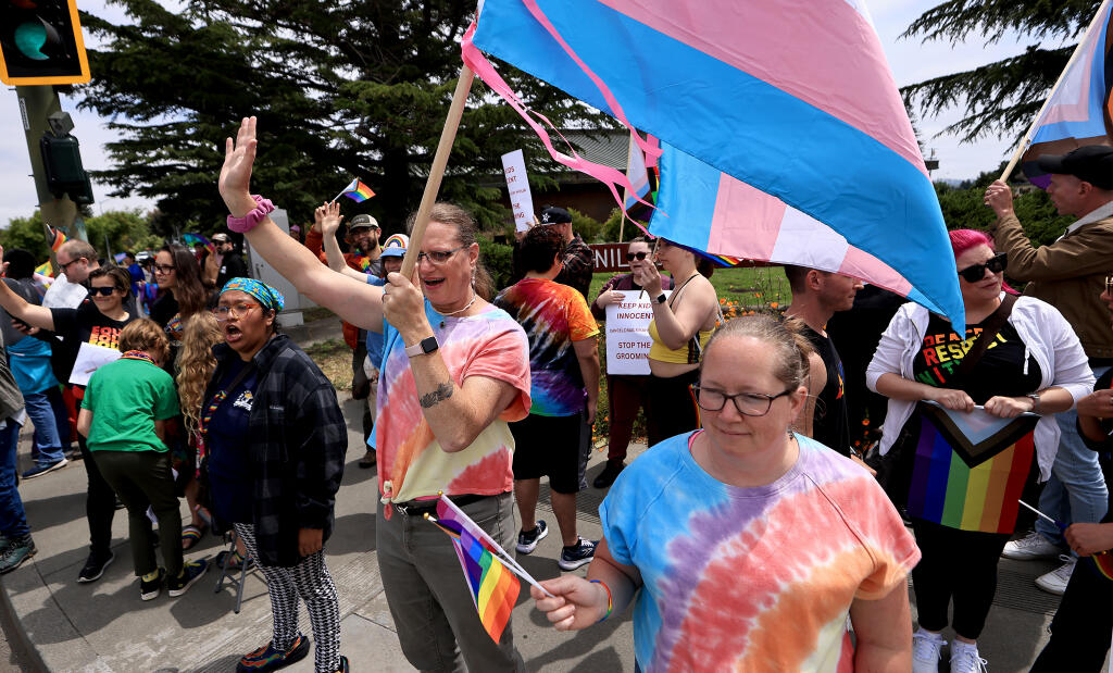 Tiesa Meskis (she, her), left, and Julie Meskis (she, her) rally with others in front of the Petaluma Library, Saturday, June 10, 2023.  (Kent Porter / The Press Democrat) 2023