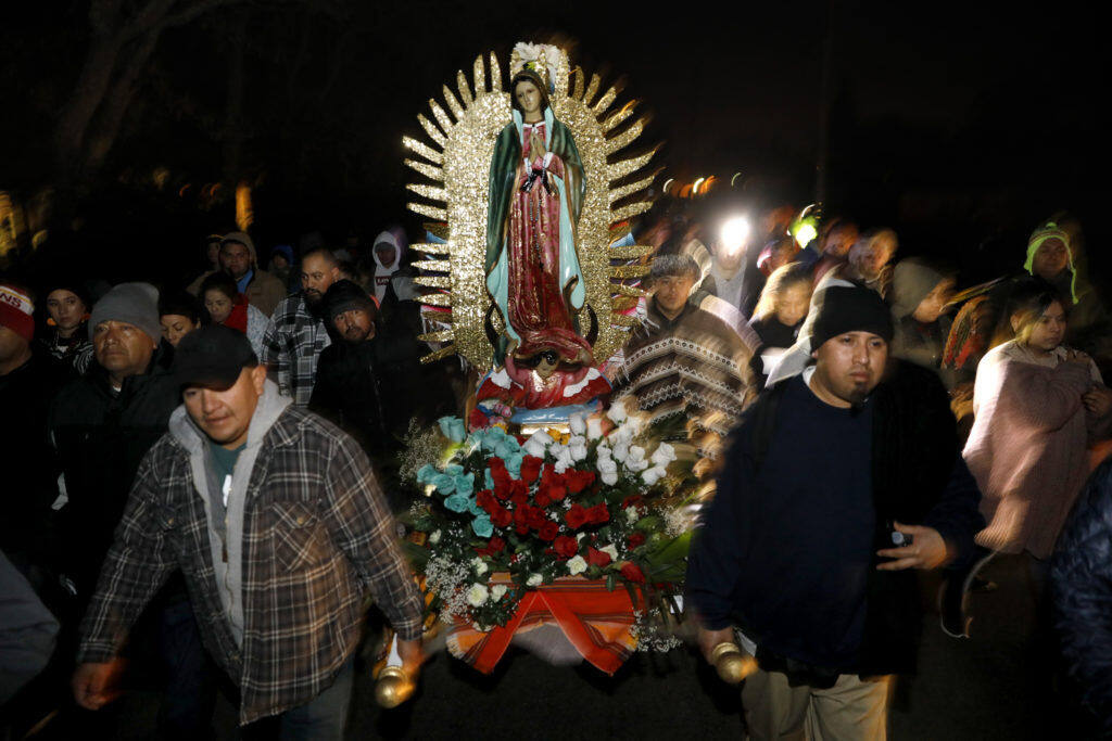 Members of a procession carry a statue of the Virgin of Guadalupe along Old Redwood Highway toward Our Lady of Guadalupe Catholic Church in Windsor on Wednesday, Dec. 12, 2018. (Beth Schlanker/The Press Democrat, 2018)