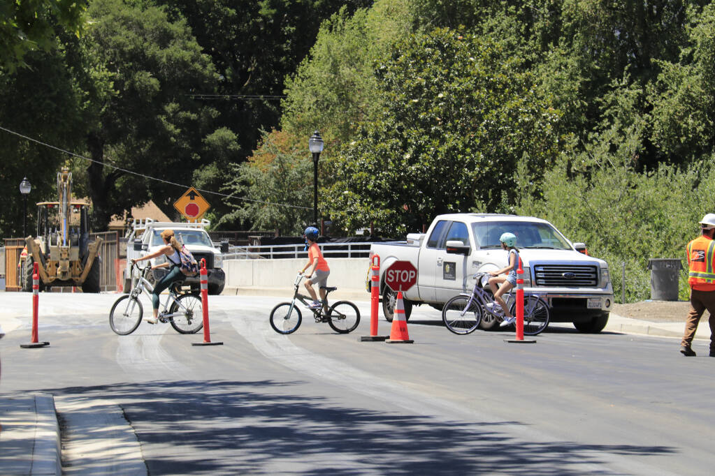 A family out for a bike ride crosses the almost-completed Boyes Boulevard Bridge, on July 12, 2021. (Index-Tribune)