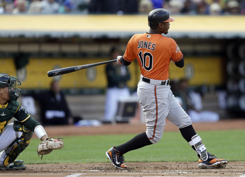 Baltimore Orioles' Adam Jones follows through on an RBI double off Oakland Athletics' Sean Manaea during the first inning of a baseball game Saturday, Aug. 12, 2017, in Oakland, Calif. (AP Photo/Ben Margot)