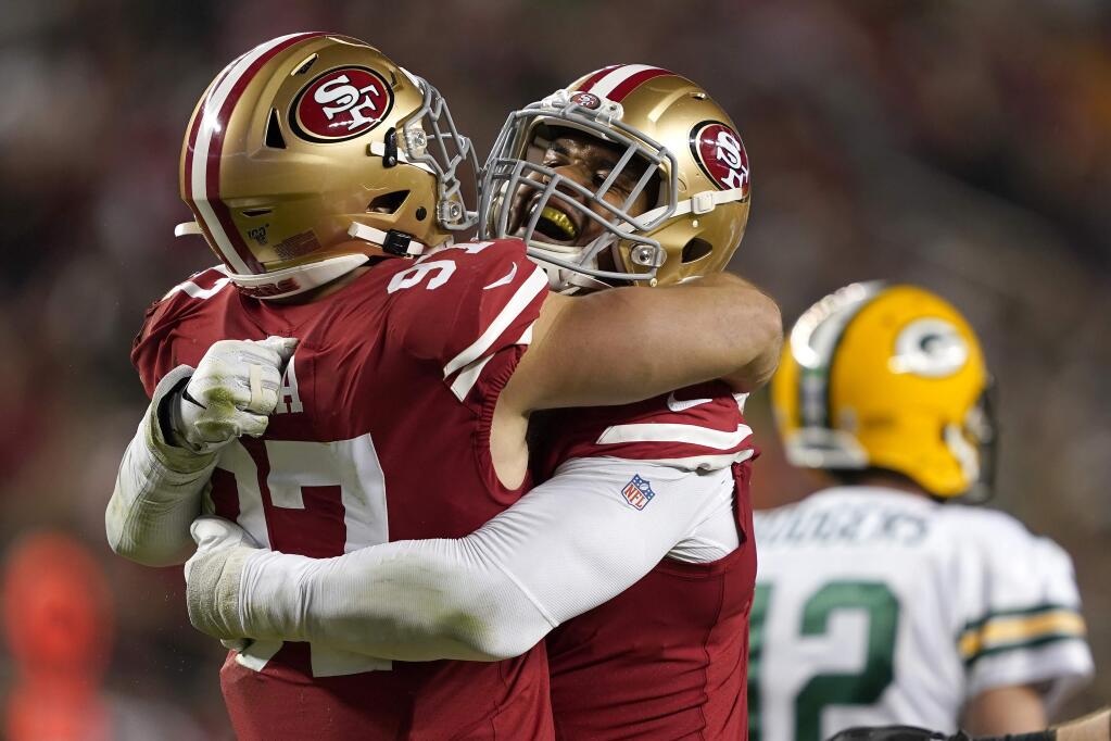 San Francisco 49ers defensive end Arik Armstead, center, is congratulated by defensive end Nick Bosa, left, after sacking Green Bay Packers quarterback Aaron Rodgers during the first half in Santa Clara, Sunday, Nov. 24, 2019. (AP Photo/Tony Avelar)