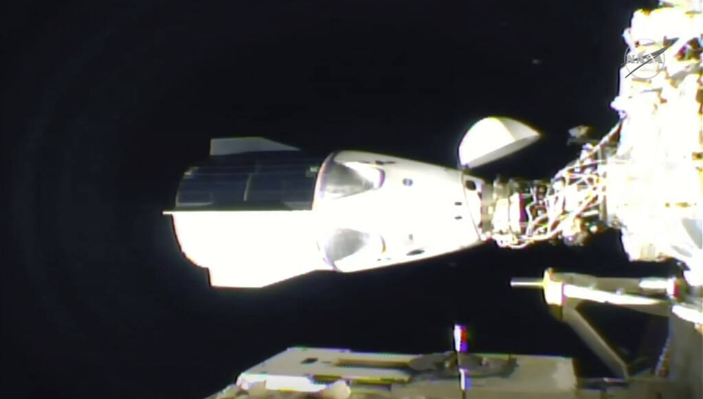 In this frame grab from NASA TV, the SpaceX Dragon is seen after docking at the International Space Station, late Monday, Nov. 16, 2020. (NASA TV via AP)