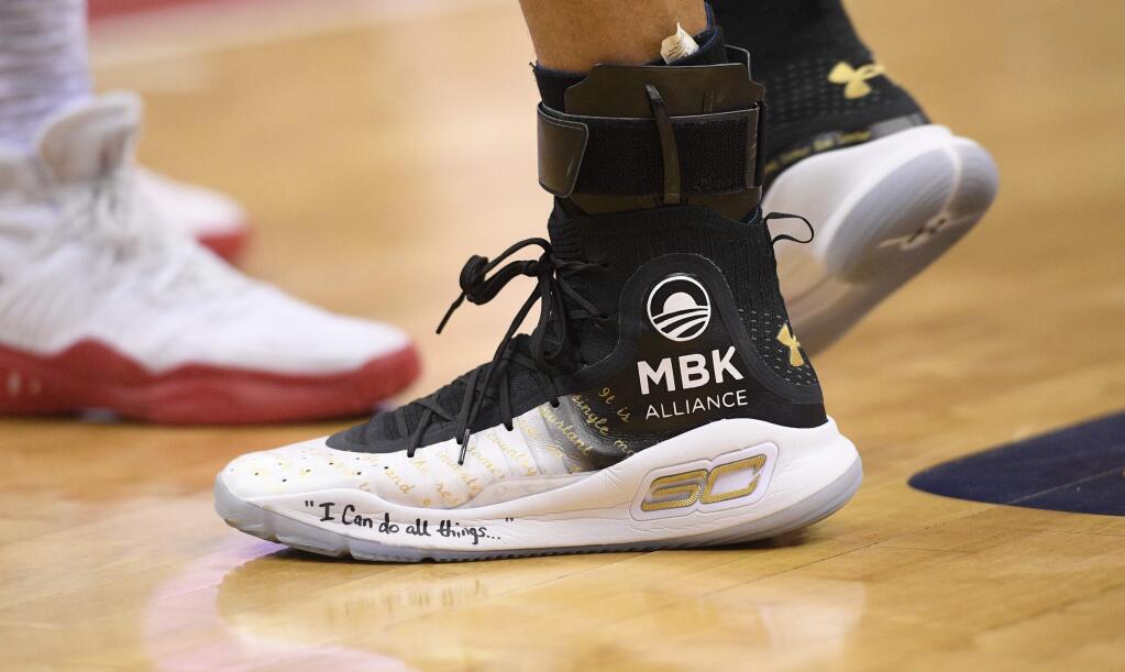 Golden State Warriors guard Stephen Curry's shoes are adorned with messages during the first half of the team's NBA basketball game against the Washington Wizards, Wednesday, Feb. 28, 2018, in Washington. (AP Photo/Nick Wass)