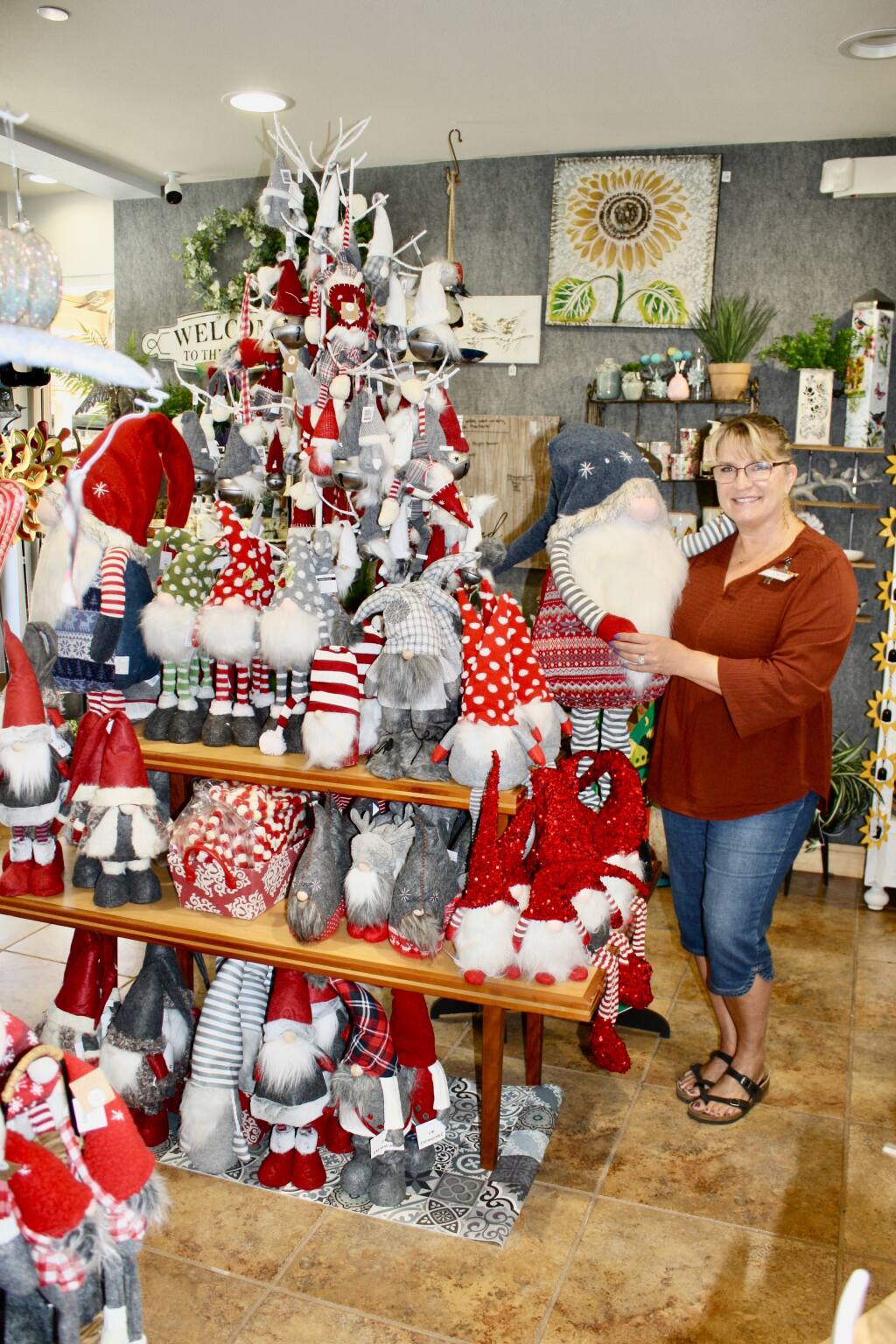 The Classic Duck at Montgomery Village shopping center in Santa Rosa set up holiday displays before Sept. 29 to meet demand from early Christmas shoppers. Lead Supervisor Carrie Knibb holds one of several dozen festive gnomes ready for adoption, a popular choice among young people and parents alike.  (Gary Quackenbush / for North Bay Business Journal)