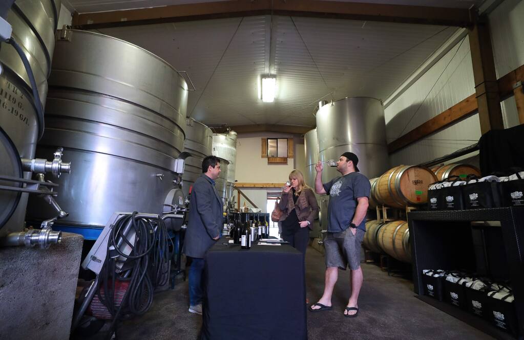 Mitch Cuadros, left, pours wine for Crystal Shermaine and Dan Nisenbaum, who travelled from Santa Clarita for the Wine Road weekend, at Christopher Creek Winery, near Healdsburg on Friday, March 13, 2020. (Christopher Chung/ The Press Democrat)