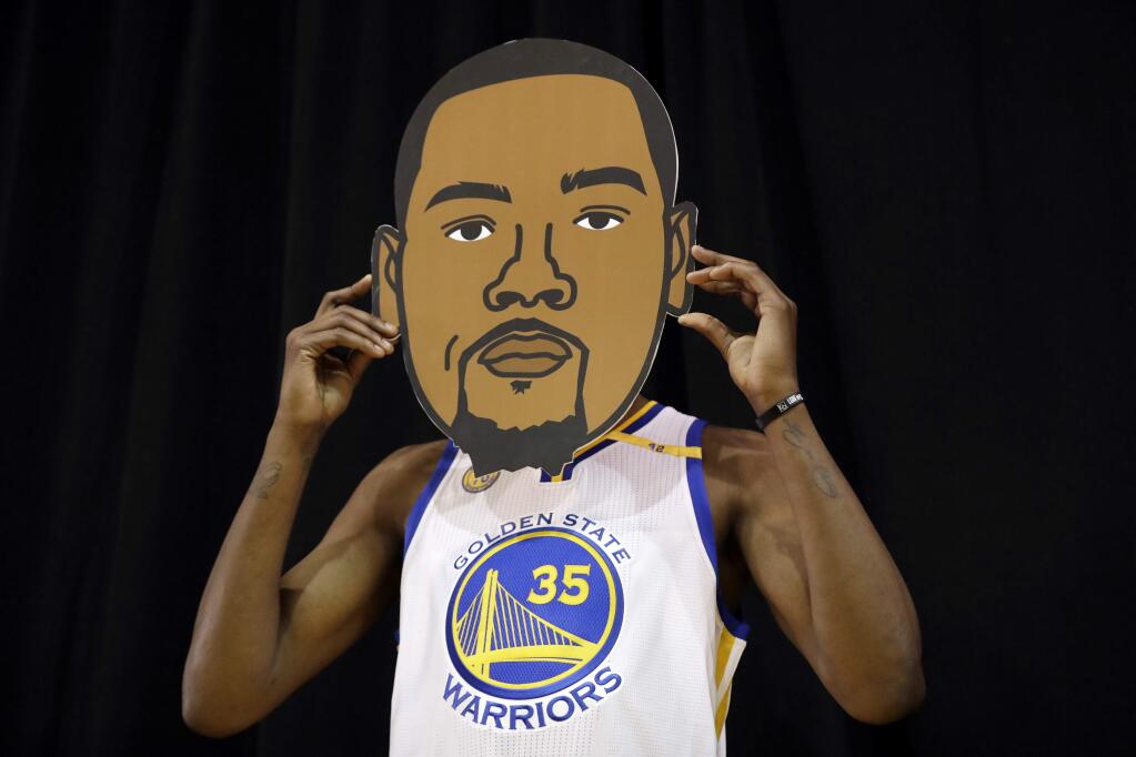 Golden State Warriors' Kevin Durant poses with a cutout with his likeness during NBA basketball media day Monday, Sept. 26, 2016, in Oakland, Calif. (AP Photo/Marcio Jose Sanchez)