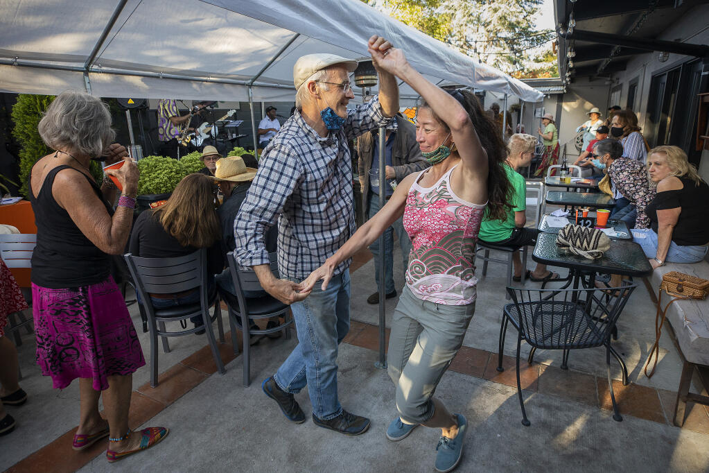 Andy Carruthers and Tina Stegner dance to the latin grooves of Batacha at Cafe Frida Gallery on the first First Friday in Santa Rosa's SoFA district since the pandemic on Friday, May 7, 2021.  (Photo by John Burgess/The Press Democrat)