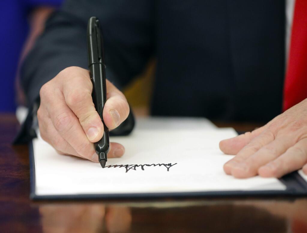 President Donald Trump signs an executive order to keep families together at the border, but says that the 'zero-tolerance' prosecution policy will continue, during an event in the Oval Office of the White House in Washington, Wednesday, June 20, 2018. (AP Photo/Pablo Martinez Monsivais)