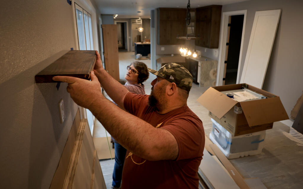 John and Angela Ghigliazza measure for locations of shelving, Friday, Nov. 5, 2021. The couple hired new contractors to finish their house in the Mark West area, after delay's by Santa Rosa-based American Pacific Builders for over a year to finish the house,   The home was destroyed in the 2017 Tubbs fire. (Kent Porter / The Press Democrat) 2021