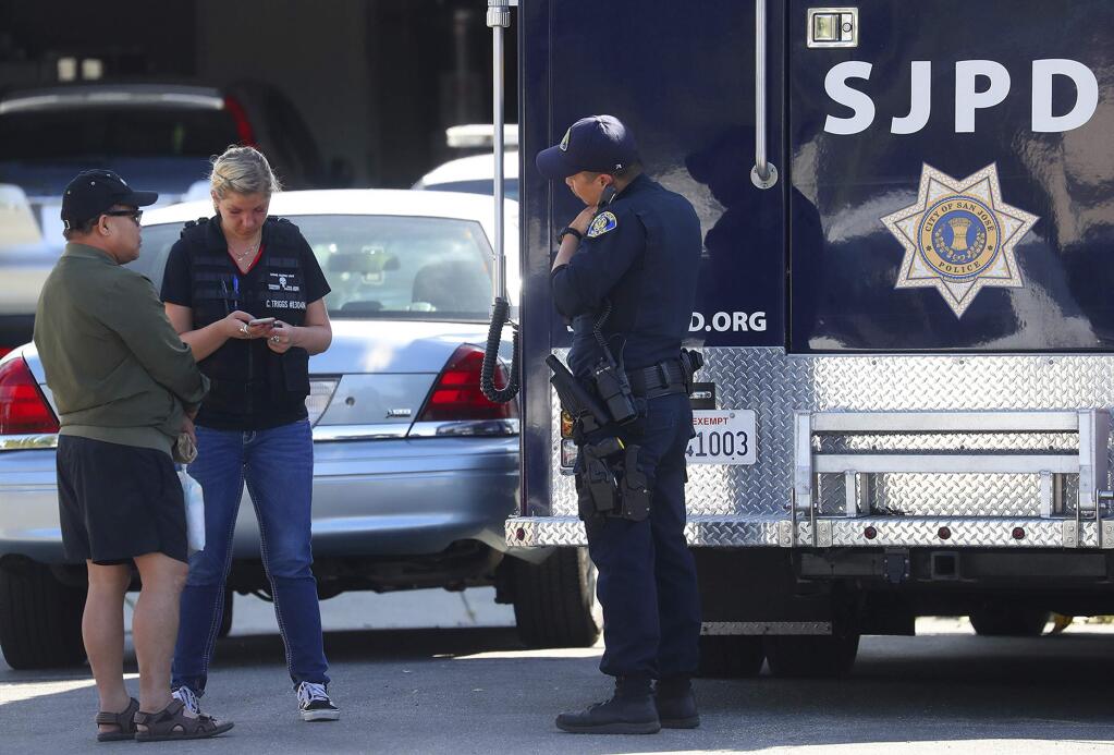 Members of the San Jose Police Department talk with an unidentified man, left, near the scene where five people were killed Monday, June 24, 2019, in San Jose, Calif. A gunman shot and killed four people then turned the gun on himself after an hours-long standoff with police in California, authorities said Monday. San Jose police saw several family members fleeing a home when police responded to multiple calls of shots fired Sunday night. (Aric Crabb/Bay Area News Group via AP)