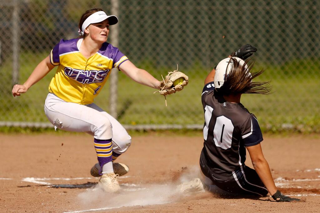 Ukiah pitcher Kelly-Ann McKeown, left, covers home plate but is not able to tag out Rancho Cotate's Makayla Barnes as she scores during a varsity softball game in Rohnert Park on Thursday, April 11, 2019. (Alvin Jornada / The Press Democrat)