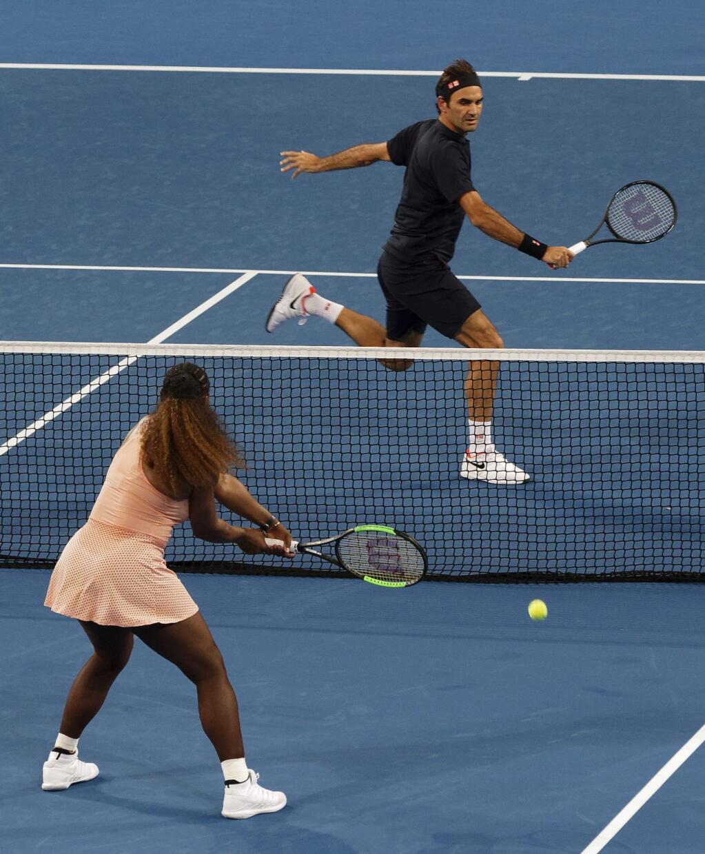 Roger Federer of Switzerland returns the ball to Serena Williams of the United States during their mixed doubles match at the Hopman Cup in Perth, Australia, Tuesday, 1, Jan. 2019. (AP Photo/Trevor Collens)
