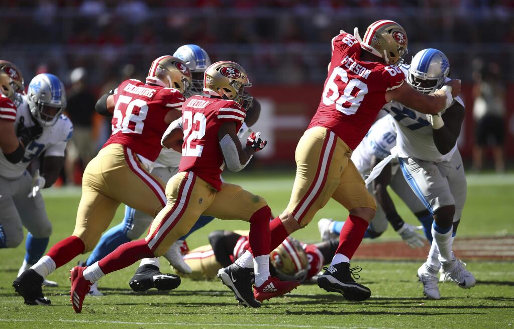 San Francisco 49ers running back Matt Breida (22) goes on a 66-yard touchdown run during the second half of an NFL football game against the Detroit Lions in Santa Clara, Calif., Sunday, Sept. 16, 2018. At left is San Francisco 49ers offensive guard Weston Richburg (58) and at right is San Francisco 49ers offensive tackle Mike Person. (AP Photo/Ben Margot)