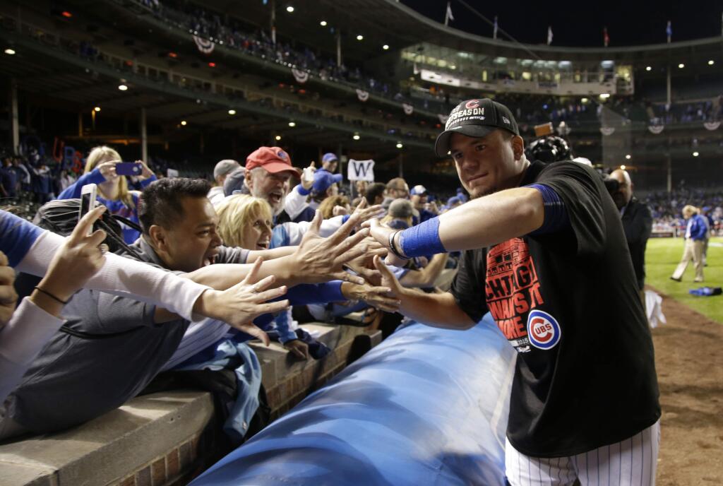 Chicago Cubs left fielder Kyle Schwarber gives high-fives to fans after the Cubs won 6-4 in Game 4 in baseball's National League Division Series against the St. Louis Cardinals, Tuesday, Oct. 13, 2015, in Chicago. (AP Photo/Nam Y. Huh)