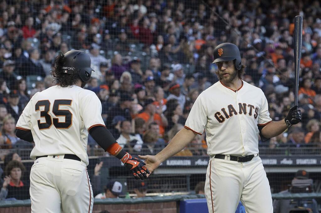 The San Francisco Giants' Brandon Crawford is congratulated by Madison Bumgarner after scoring against the Pittsburgh Pirates during the second inning Tuesday, July 25, 2017. (AP Photo/Jeff Chiu)