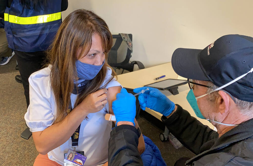 FILE - In this Feb. 19, 2021, file photo, Grace John, who works at a school in San Lorenzo, gets a COVID-19 shot at a mobile vaccination clinic run by the Federal Emergency Management Agency and the state in Hayward, Calif. (AP Photo/Terry Chea, File)