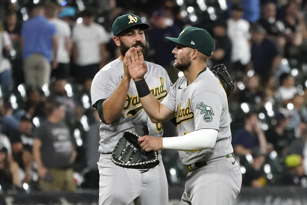 Athletics relief pitcher Lou Trivino, left, and Seth Brown celebrate the team’s 7-3 win over the White Sox Friday, July 29, 2022, in Chicago. (Charles Rex Arbogast / ASSOCIATED PRESS)
