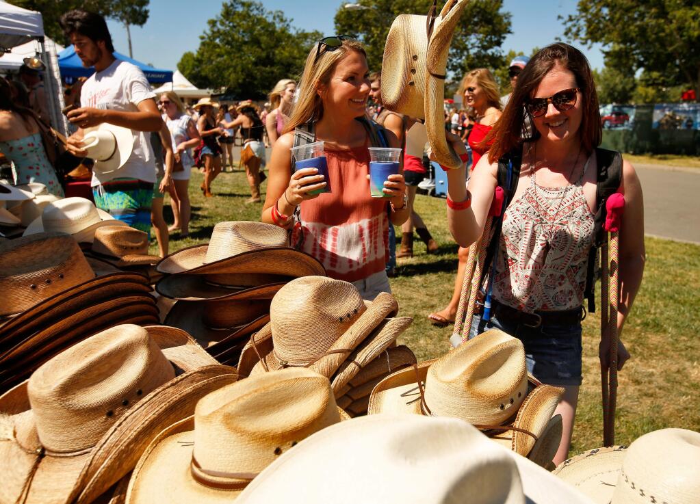 Jayme Greeson and Natalie Knight take a look at cowboy hats during day two of Country Summer at the Sonoma County Fairgrounds in Santa Rosa in 2017. (Alvin Jornada / The Press Democrat)