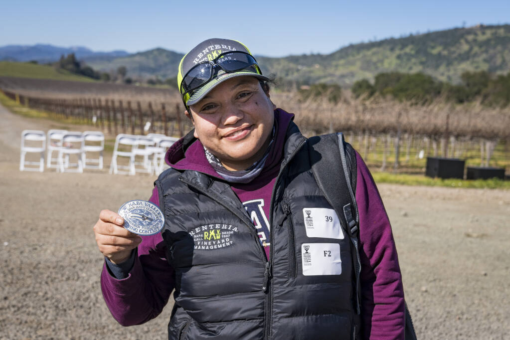 Erika López of Renteria Vineyard Management shows off the silver belt buckle trophy for winning first place in the women's division at Napa Valley Grapegrowers' 20th annual Napa County Pruning Contest at Beringer's Gamble Ranch Vineyard on Saturday, Feb. 5, 2022. (Suzanne Becker Bronk photo)