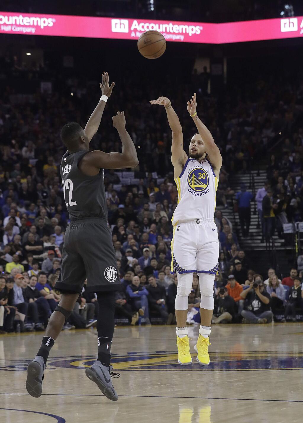 Golden State Warriors guard Stephen Curry (30) shoots over Brooklyn Nets guard Caris LeVert (22) during the first half of an NBA basketball game in Oakland, Calif., Tuesday, March 6, 2018. (AP Photo/Jeff Chiu)