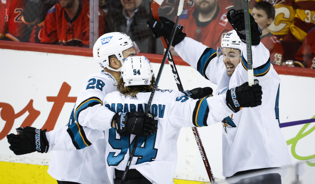 The San Jose Sharks’ Alexander Barabanov, center, celebrates his goal against the Flames with Timo Meier, left, and Tomas Hertl during the third period on Tuesday, March 22, 2022, in Calgary, Alberta. (Jeff McIntosh / Canadian Press)