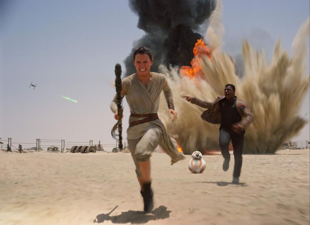 This photo provided by Disney shows Daisey Ridley as Rey, left, and John Boyega as Finn, in a scene from the new film, 'Star Wars: The Force Awakens.' (Film Frame/Disney/Lucasfilm via AP)