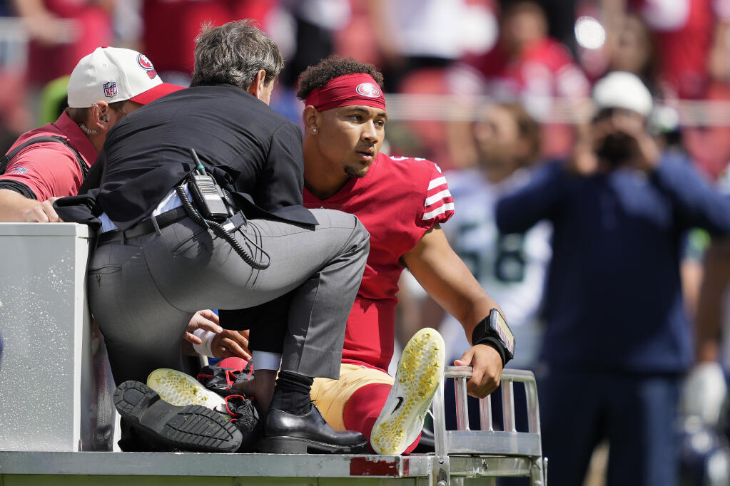 49ers quarterback Trey Lance is carted off the field during Sunday’s game against the Seattle Seahawks in Santa Clara. (Tony Avelar / ASSOCIATED PRESS)