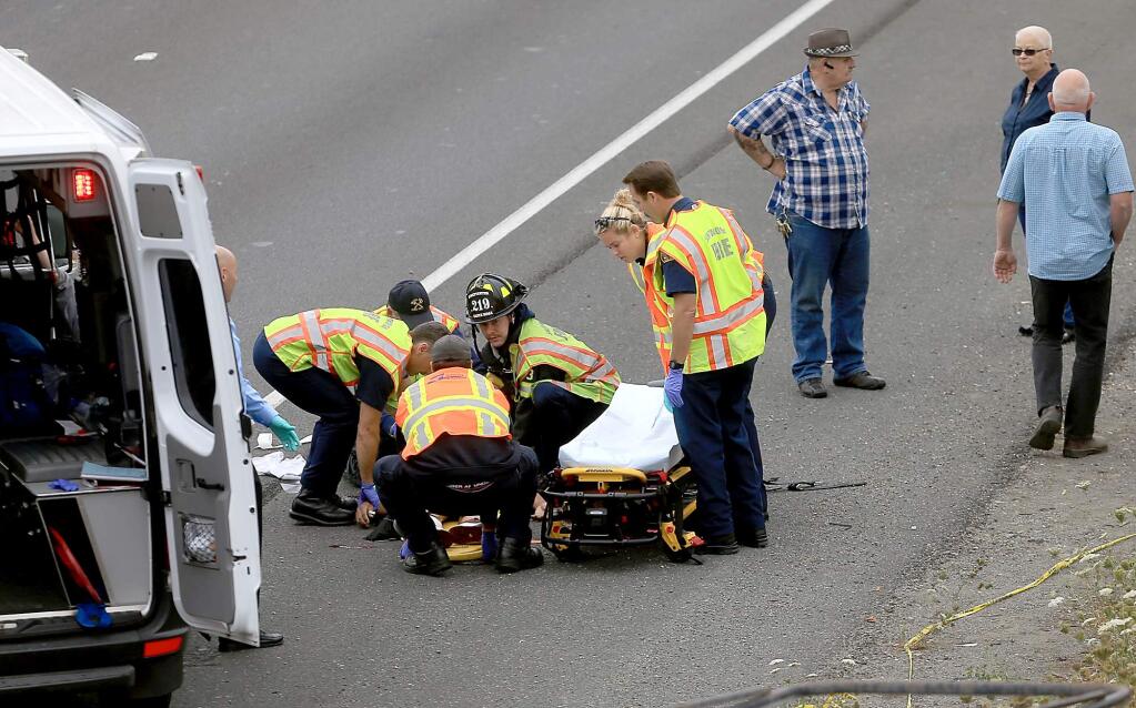 Santa Rosa firefighters and Sonoma Life Support personnel perform chest compressions on a man who was hit by a vehicle on north Highway 101 near Bicentennial Way, Thursday Aug. 20, 2015 in Santa Rosa. (Kent Porter / Press Democrat) 2015