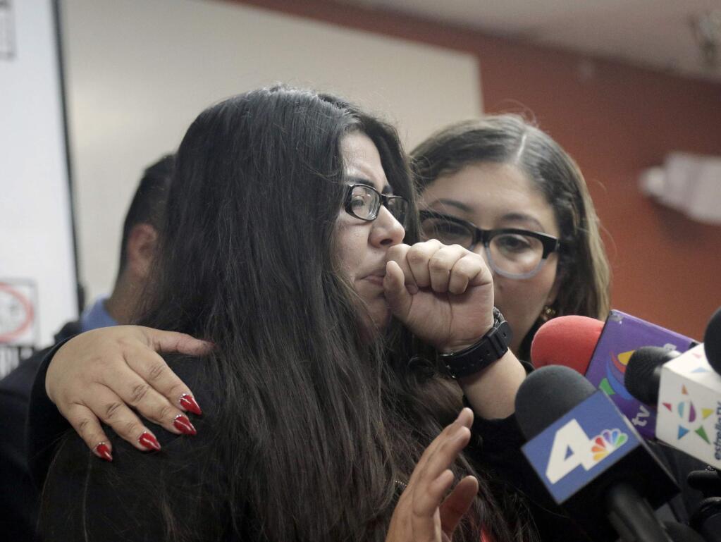 Marlene Mosqueda, left, who's father was deported early Friday, Feb. 10, 2017, is comforted at a news conference by her attorney Karla Navarrette at The Coalition for Humane Immigrant Rights of Los Angeles (CHIRLA). Navarrete, said she sought to stop Mosqueda from being placed on a bus to Mexico and was told by ICE that things had changed. She said another lawyer filed federal court papers to halt his removal. (AP Photo/Nick Ut)