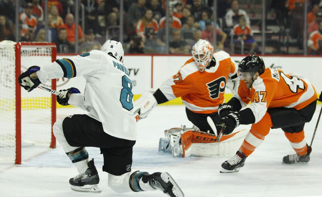 The San Jose Sharks' Joe Pavelski, left, scores against the Philadelphia Flyers' Brian Elliott, center, and Andrew MacDonald, right, during the first period Tuesday, Oct. 9, 2018, in Philadelphia. (AP Photo/Tom Mihalek)