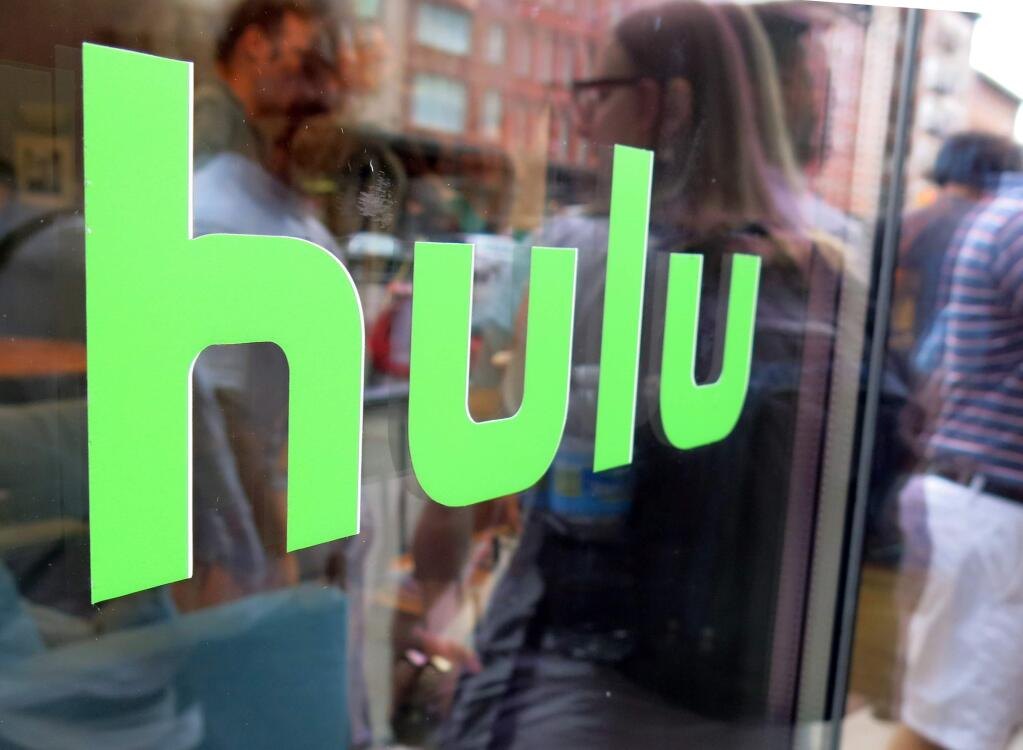 FILE - This Saturday, June 27, 2015, file photo, shows the Hulu logo on a window at the Milk Studios space in New York. Hulu will offer a live-streaming service in 2017 that will offer a mix of cable and broadcast programming as well as news, sports and events. That pits the streaming service against similar offerings from Sling TV and PlayStation Vue as more and more Americans shift to watching TV online. (AP Photo/Dan Goodman, File)