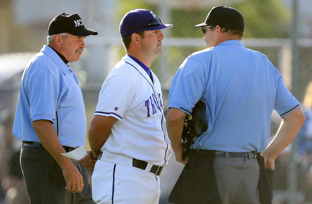 Petaluma head coach Paul Cochrun talks with umpires about an overturned call that went against Petaluma during a marathon 15-inning, 1-0 loss to Analy in 2014. (Kent Porter / Press Democrat)