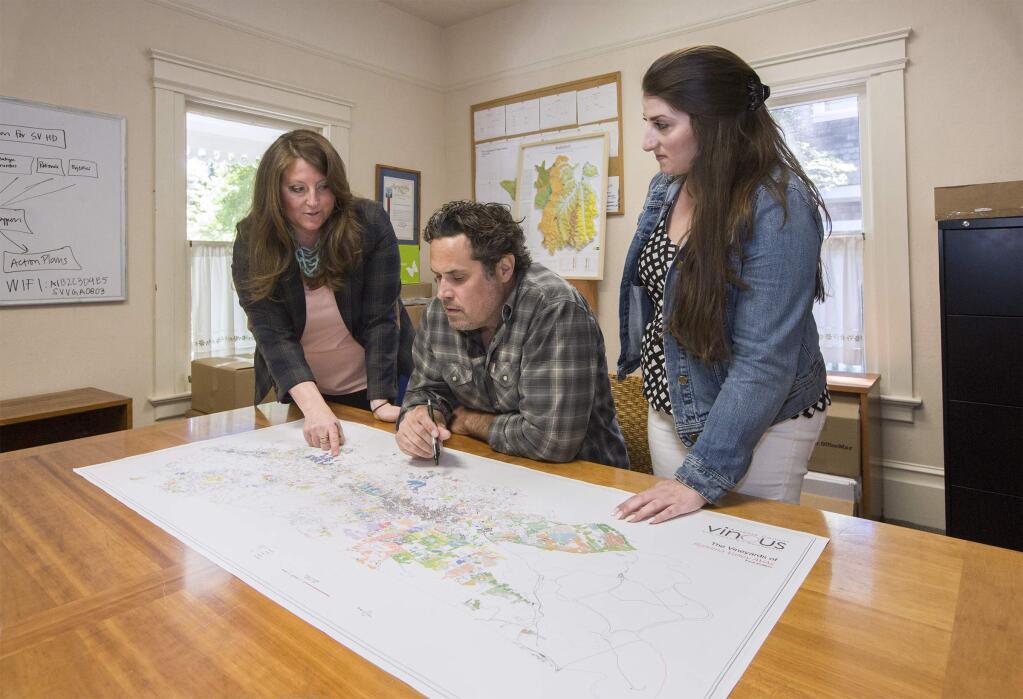 From left, Maureen Cottingham, executive director Sonoma Valley Vintners & Growers Alliance, Kenneth Juhasz, past president of SVVGA and owner and winemaker of Auteur Wines, and Adriana Duckworth, member relations and sponsorship director, SVVGA, pour over their new map that charts every single vineyard of at least a quarter acre in Sonoma Valley. (Photo by Robbi Pengelly/Index-Tribune)