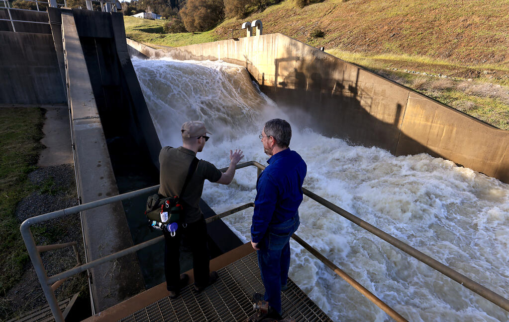 KRCB reporter Noah Abrams, left, talks with Chris Schooley, operations project manager with the Army Corps of Engineers, as 4,000 cfs of Lake Sonoma water is released, Wednesday, March 15, 2023. (Kent Porter / The Press Democrat)